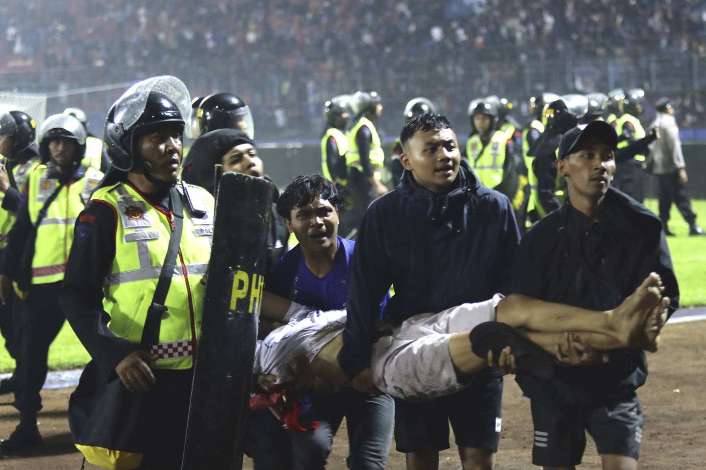 Aficionados cargan a un hombre herido en los enfrentamientos durante un partido de fútbol en Malang, Indonesia.