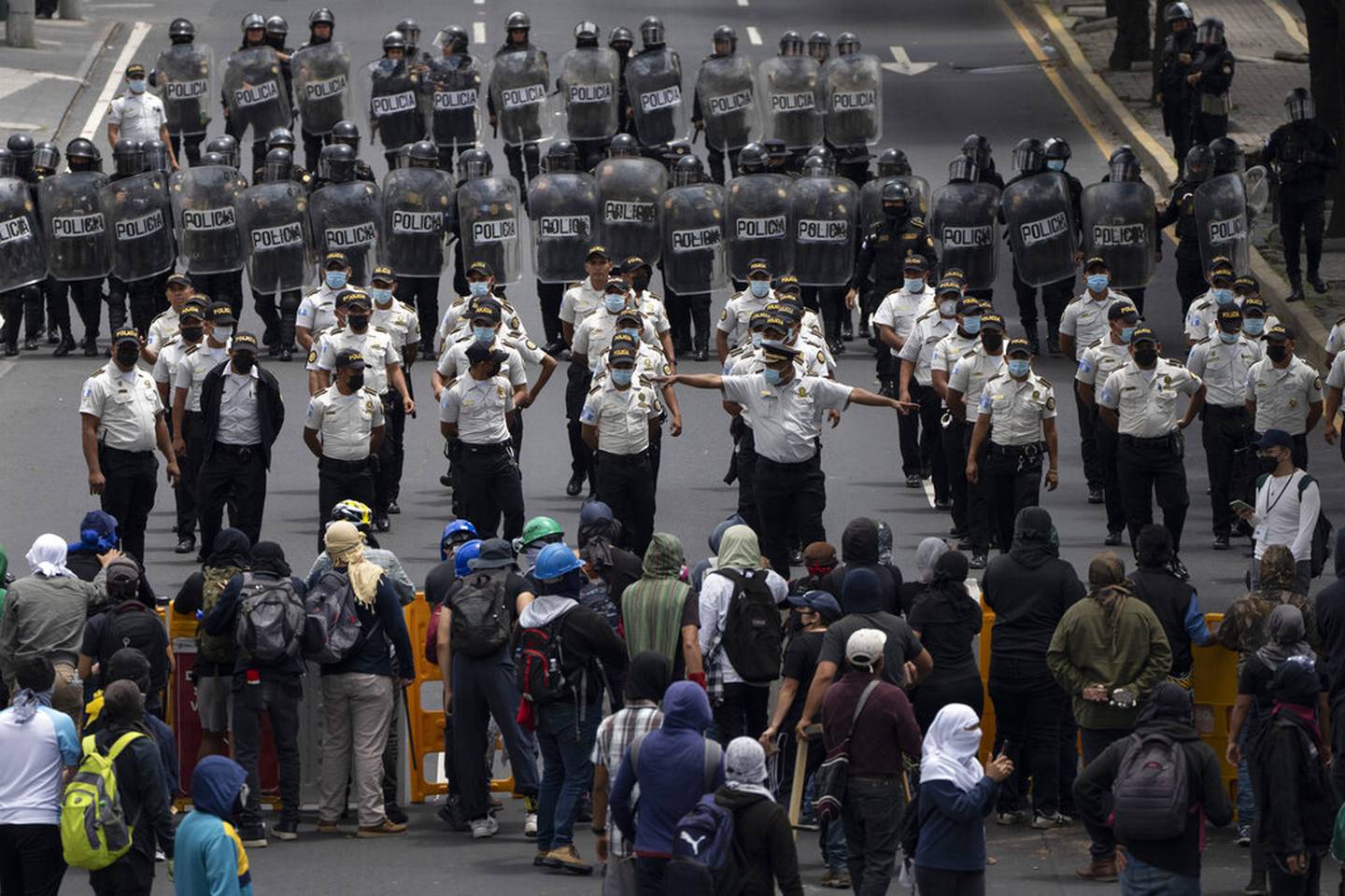 La policía intenta despejar una calle bloqueada por estudiantes universitarios cerca de la universidad pública de San Carlos durante una protesta antigubernamental en Ciudad de Guatemala, el martes 9 de agosto de 2022.