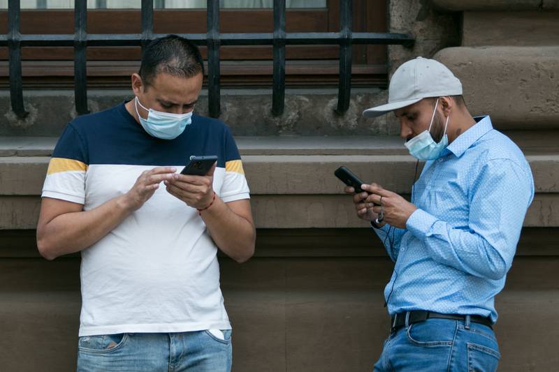 Dos hombres utilizan su teléfono celular en las inmediaciones del Centro Histórico. Foto: Cuartoscuro