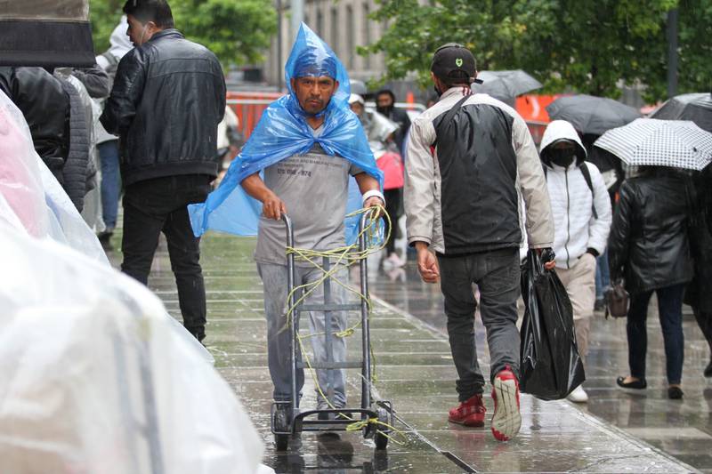 Capitalinos se cubren con paraguas e impermeables de las lluvias presentes esta tarde en el Valle de México. Foto: Cuartoscuro