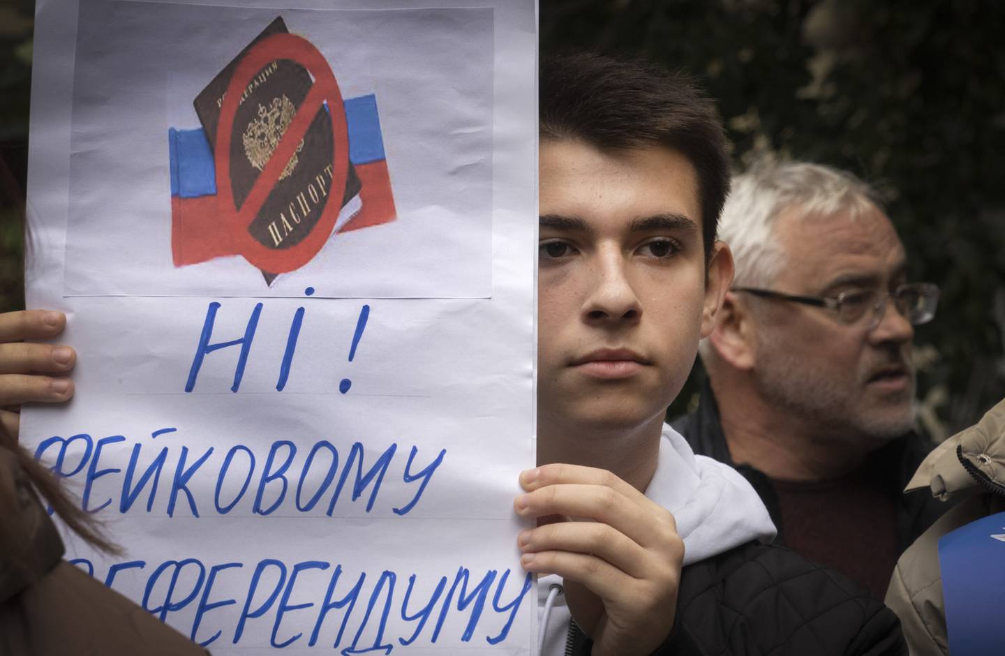 Un manifestante sostiene un cartel que dice: "¡No! a un falso referéndum", mientras los residentes de Mariupol asisten a una manifestación contra un referéndum orquestado por el Kremlin en Kiev, Ucrania, el sábado 24 de septiembre de 2022. La votación comenzó el viernes en cuatro regiones de Ucrania controladas por Moscú sobre los referendos para formar parte de Rusia. (AP Photo/Efrem Lukatsky)