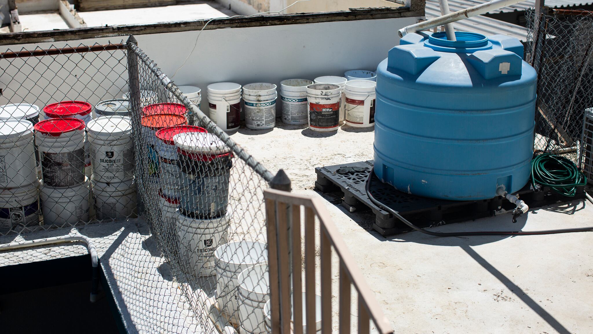 Más de una decena de cubos y una cisterna azul llenas de aguas en una residencia en Moca.
