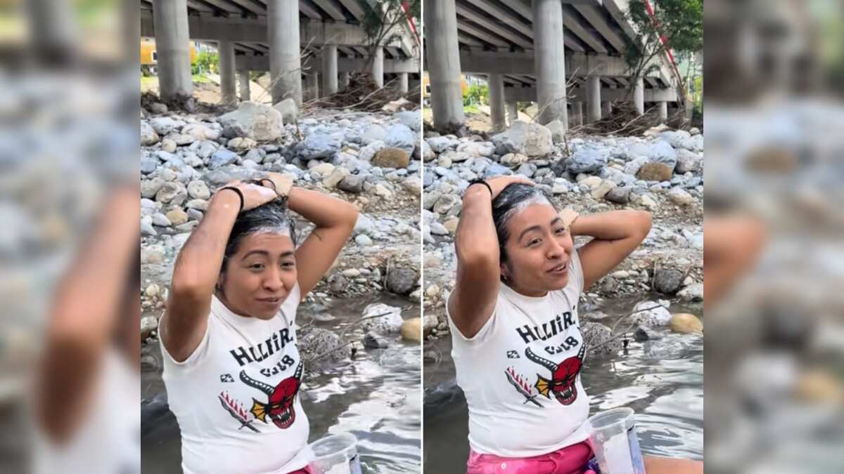 La joven se lava el cabello en un charco de agua cristalina.