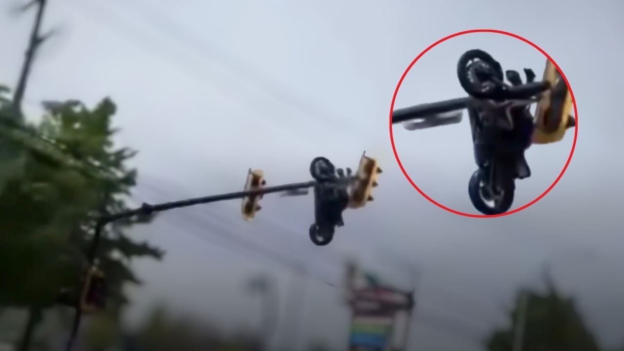 Moto queda colgando en semáforo