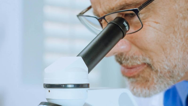 Científico observa por el lente de un microscopio