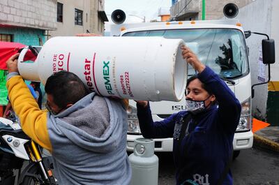 Una pareja carga su nuevo tanque de gas Bienestar.