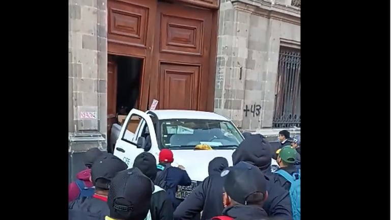 Normalistas derriban puerta de Palacio Nacional