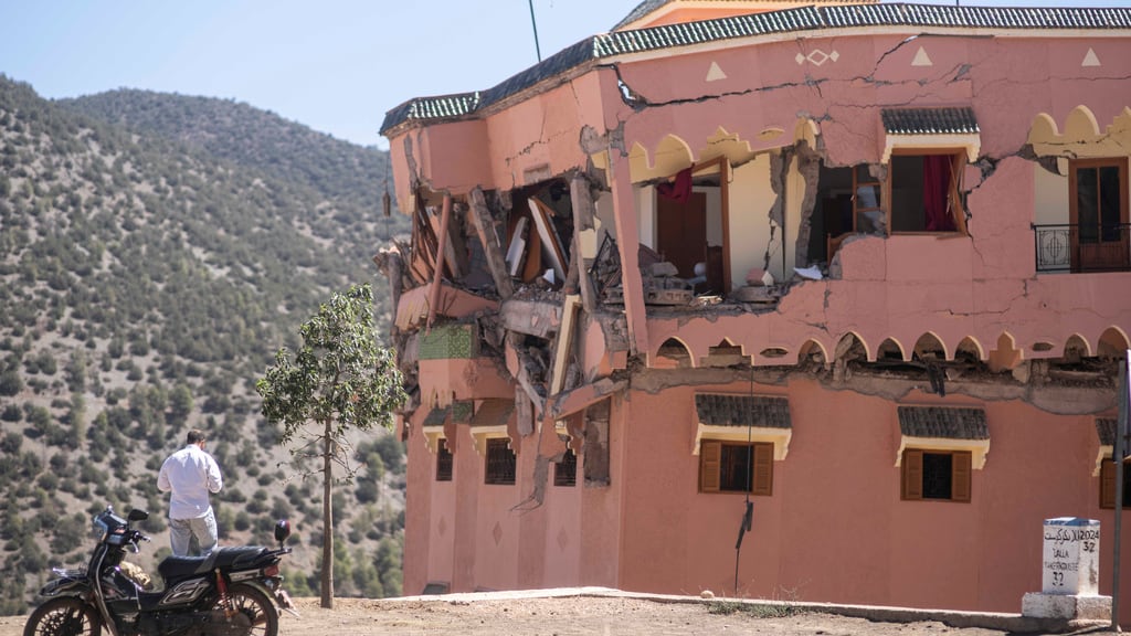 Un hombre de pie junto a un hotel dañado por un sismo en el poblado de Moulay Brahim, cerca del epicentro del sismo, a las afueras de Marrakech, Marruecos, el sábado 9 de septiembre de 2023. (AP Foto/Mosa'ab Elshamy)