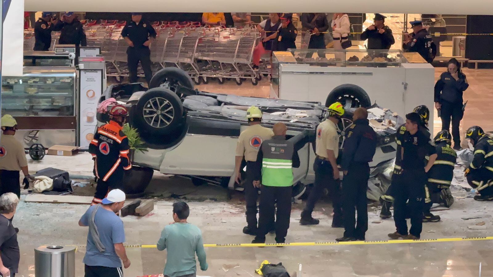 Personal de Seguridad asistiendo a mujer que cayó tres pisos de plaza comercial