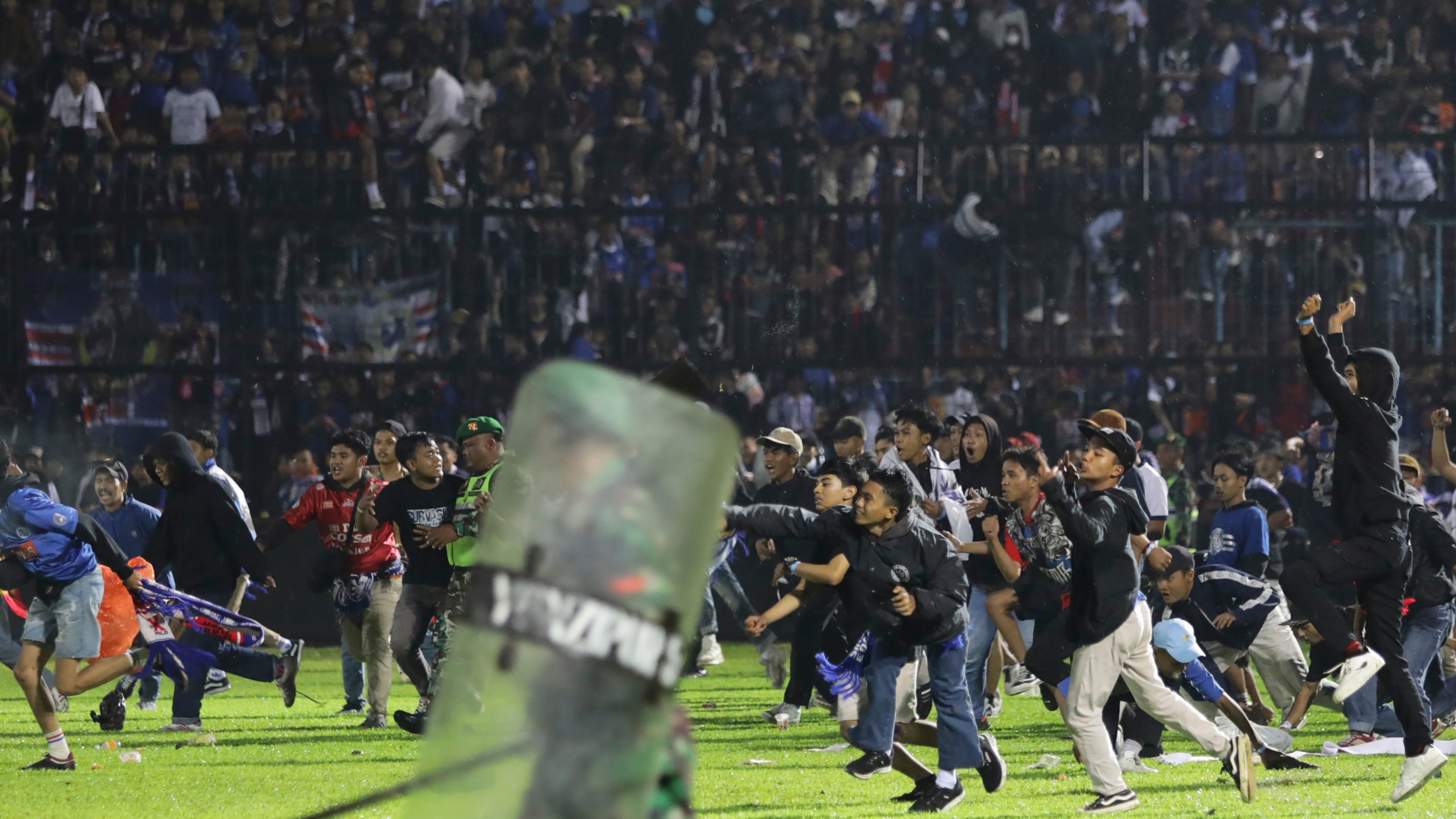 Aficionados al fútbol corren durante una serie de enfrentamientos en Indonesia