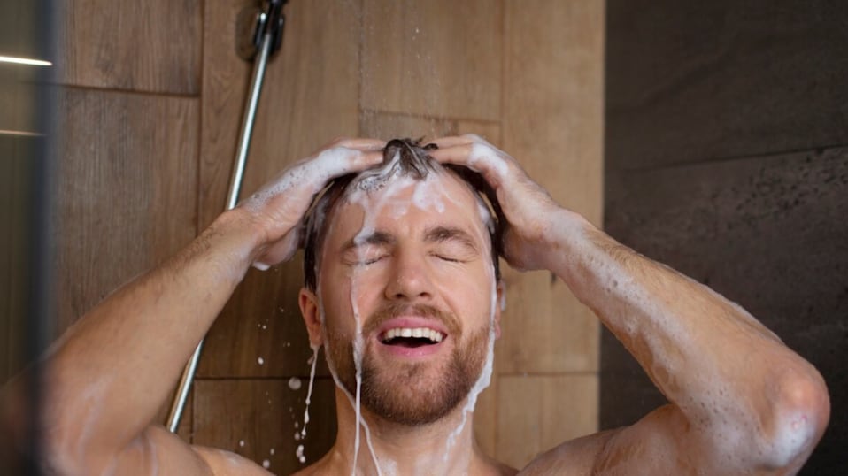 Vista frontal hombre lavando el cabello