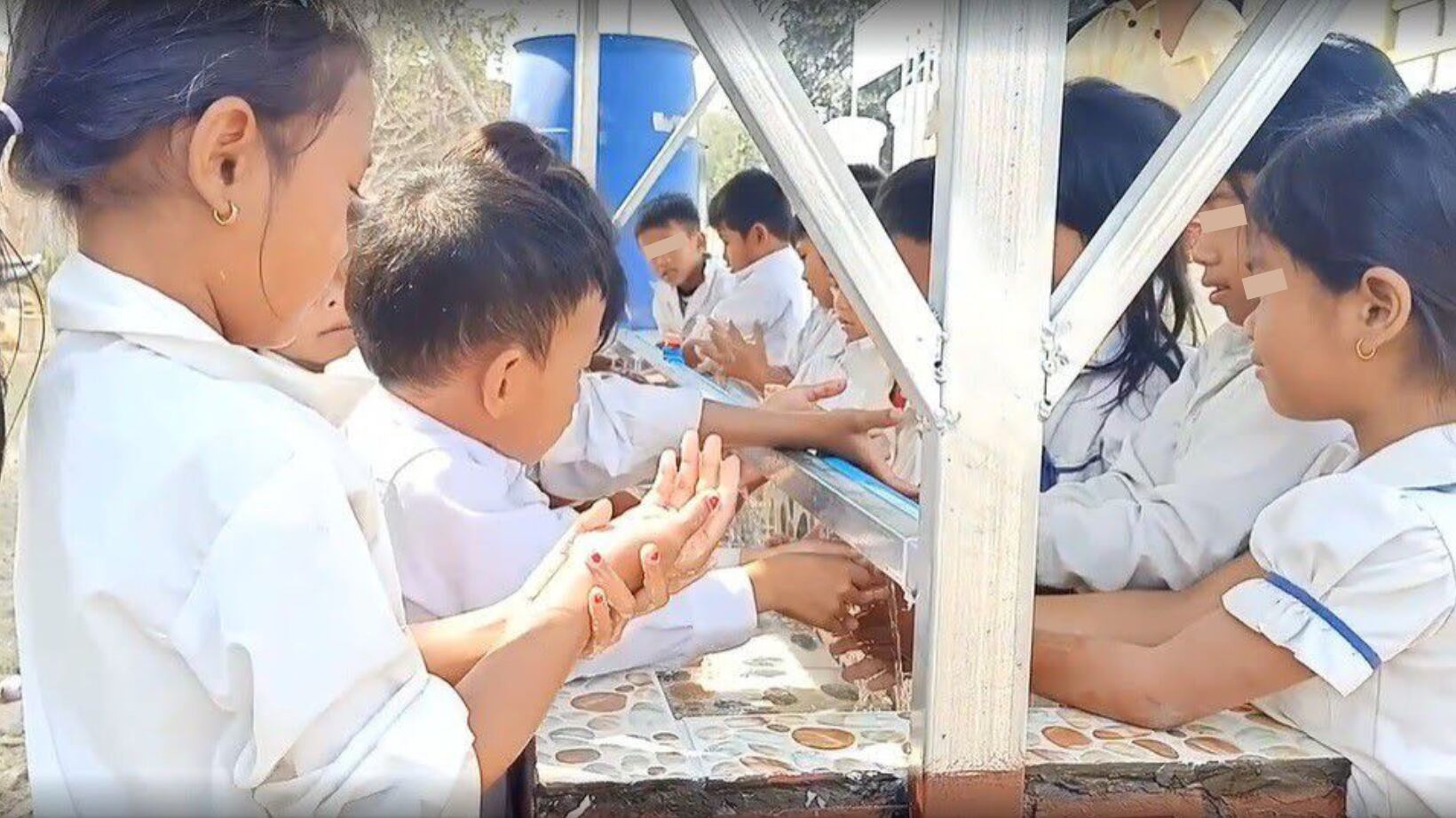 Alumnos de la escuela de Broylatngor, en Camboya, se lavan las manos en el lavabo comunitario construido gracias a la colaboración entre AUARA y la organización Karuna Battambang.