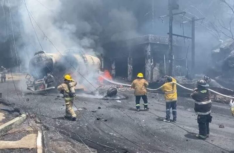 Bomberos intentan apagar el fuego ocasionado por la explosión de la pipa.