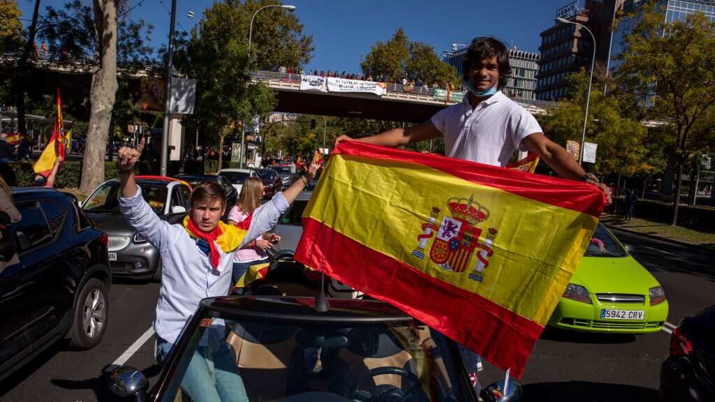MADRID, ESPAÑA - 12 DE OCTUBRE: Un manifestante sostiene una bandera española durante una protesta en un vehículo contra el gobierno español a lo largo del Paseo de la Castellana en el Día Nacional de España durante la segunda ola de la pandemia de Covid-19 el 12 de octubre de 2020 en Madrid, España . El partido de extrema derecha VOX ha llamado a sus seguidores a protestar en toda España, contra el gobierno español, después de declarar el estado de emergencia en la ciudad de Madrid para activar las restricciones de movilidad para controlar la propagación de la enfermedad por coronavirus. Madrid es en estos momentos la ciudad más golpeada de Europa por la pandemia del Covid-19 (Fotografía de Pablo Blazquez Domínguez/Getty Images)