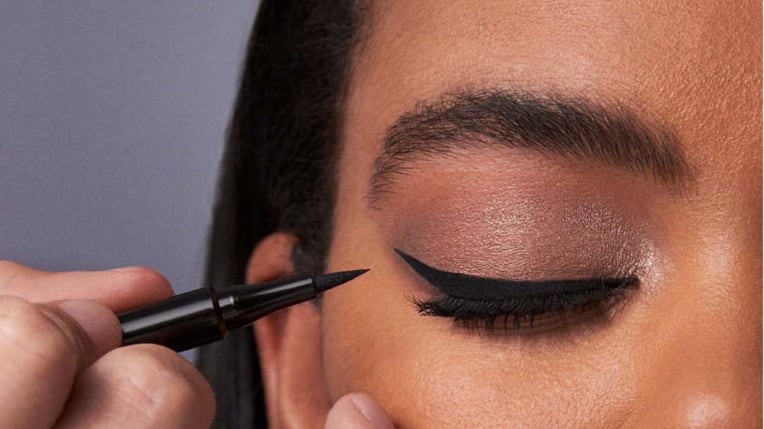 Foto de mulher aplicando delineador nos olhos