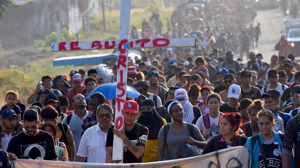Migrantes que caminan por la carretera llevan una cruz que dice en español "Cristo Resucitado" durante la Semana Santa mientras avanzan por Tapachula en el estado mexicano de Chiapas, el lunes 25 de marzo de 2024. (AP Foto/Edgar H. Clemente)