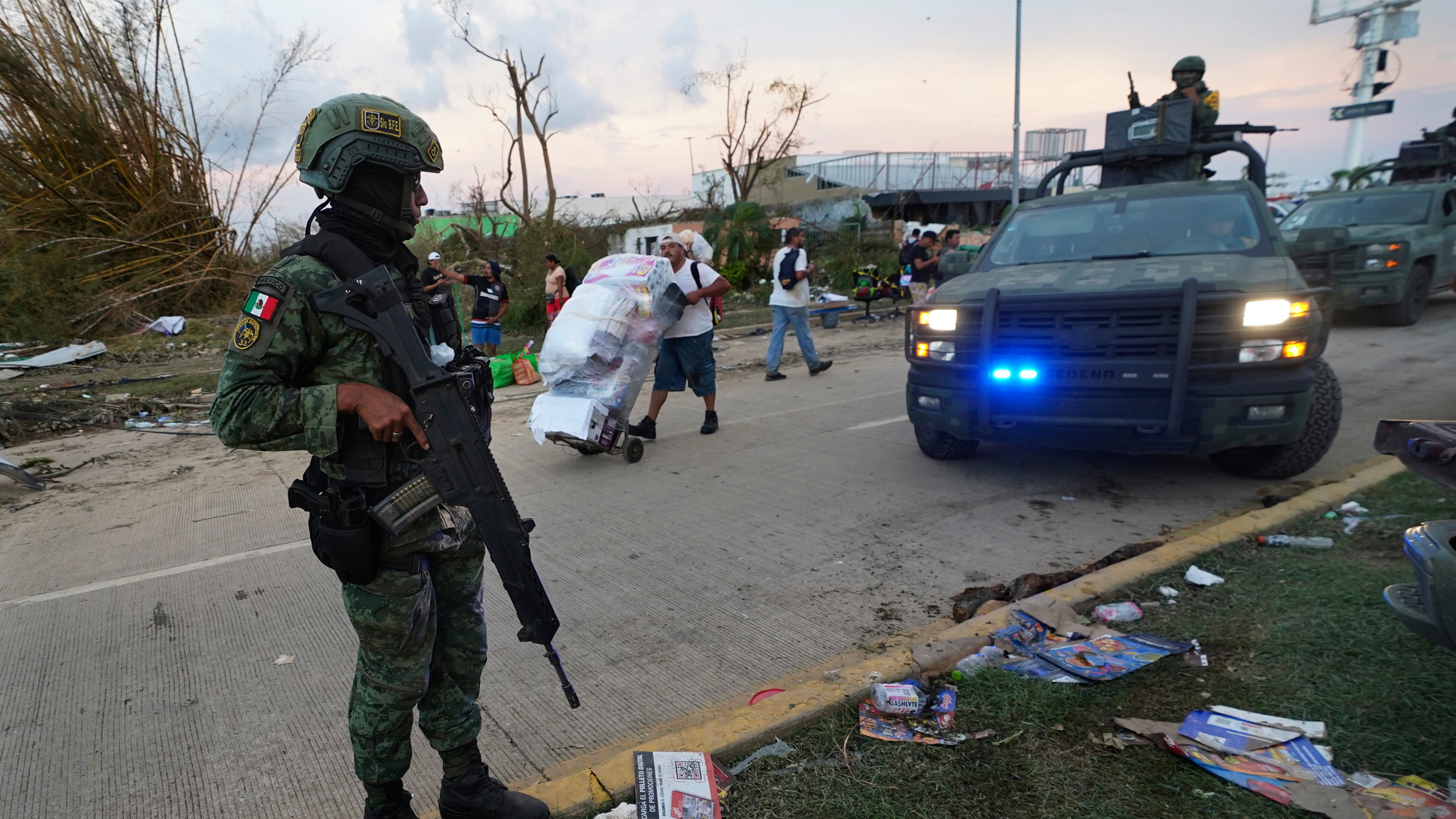 Los soldados vigilan las calles mientras los residentes toman artículos de las tiendas locales después de que el huracán Otis arrasó Acapulco, México, el jueves 26 de octubre de 2023. Después de que el huracán Otis arrasó Acapulco, México, el jueves 26 de octubre de 2023. Muchos residentes estaban tomando productos básicos artículos de las tiendas para sobrevivir. Otros se marcharon con productos más caros, provocando alborotos generalizados en las tiendas de la zona. (Foto AP/Marco Ugarte) (Foto AP/Marco Ugarte)