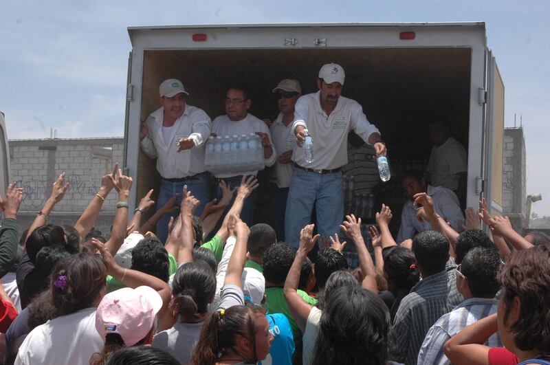ECATEPEC, ESTADO DE MÉXICO, 11JUNIO2009.- Cientos de personas de municipios como Acolman, Teotihuacan, Zumpango y Coacalco, entre otras,  fueron trasladadas en camiones
para estar en el evento de inauguración del Colector Ozumbilla-"Margarito F. Ayala", en Santo Tomás Chiconautla, encabezado por el gobernador, Enrique Peña Nieto. Debido a que permanecieron durante varias horas y el calor estuvo en todo su esplendor, los asistentes buscaban obtener una botella de agua y el "lunch" que les prometieron, coincidieron priistas asistentes.
FOTO: MARIO NULO/CUARTOSCURO.COM