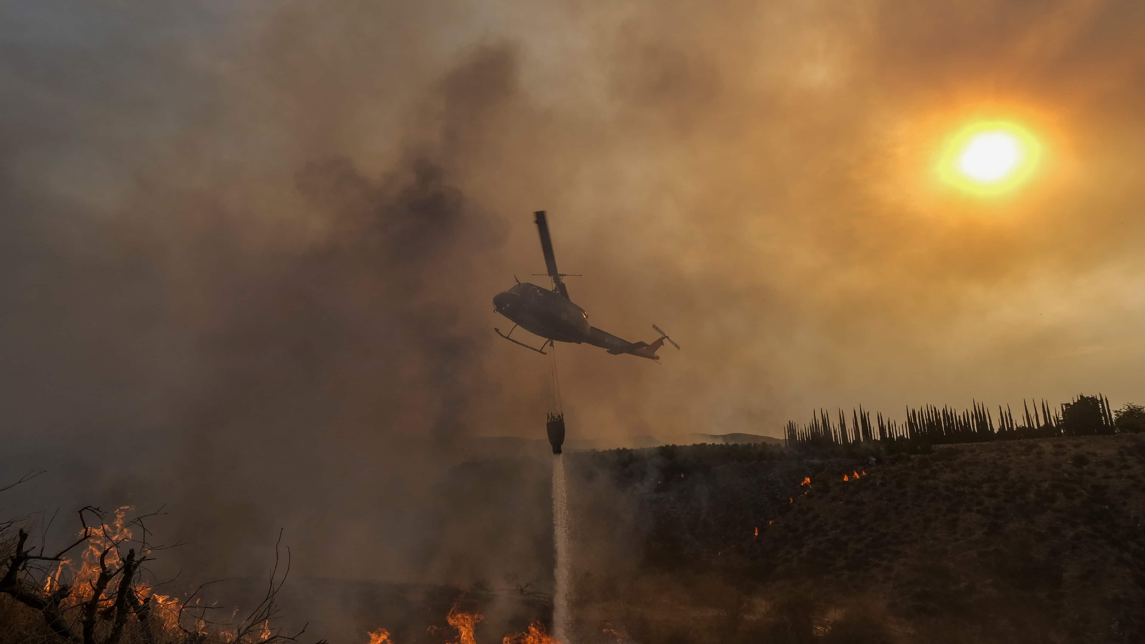 Un helicóptero lanza agua sobre el incendio Fairview en una ladera el jueves 8 de septiembre de 2022, cerca de Hemet, California.