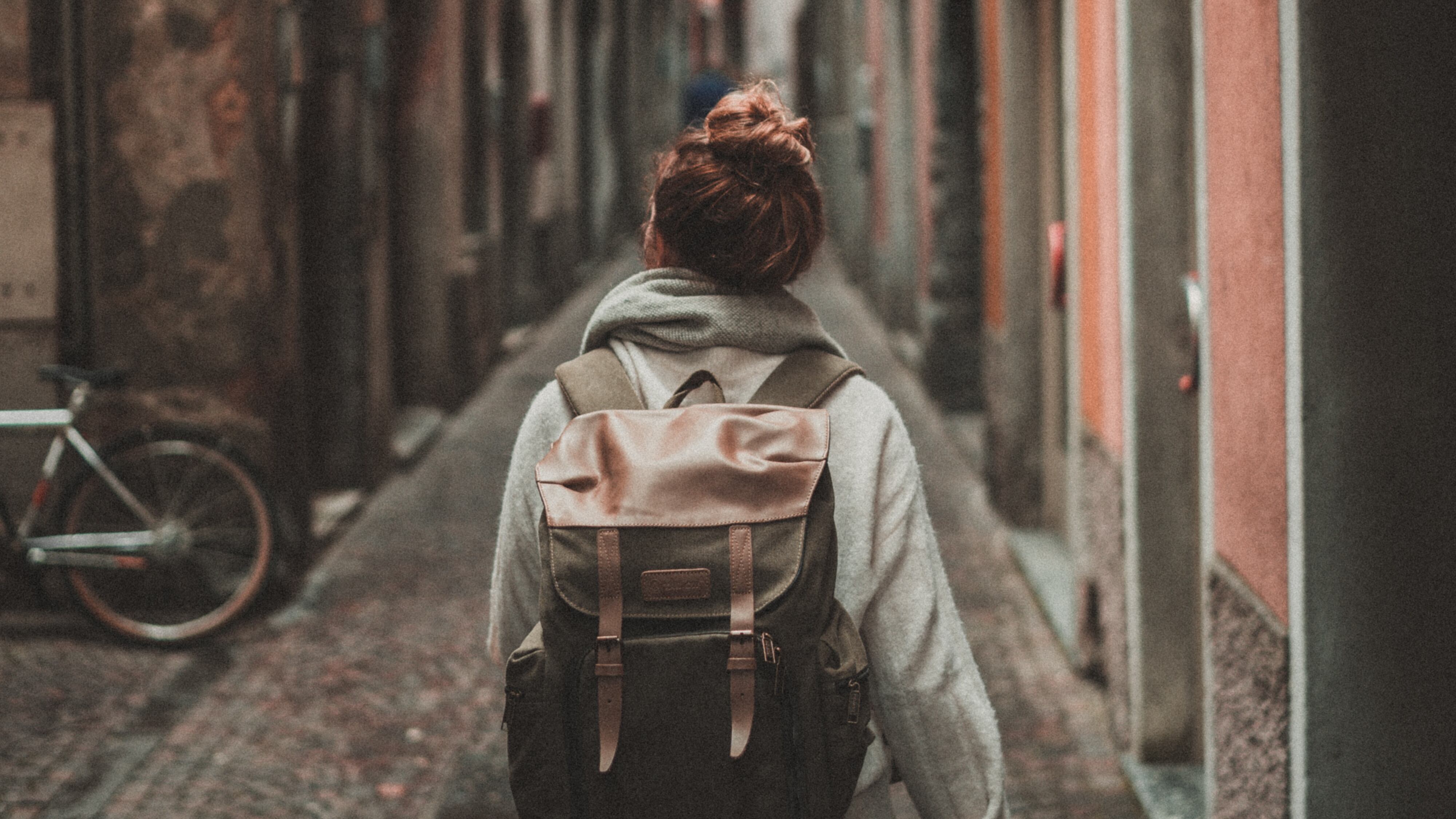 viajera de bajo presupuesto caminando por la calle con una mochila