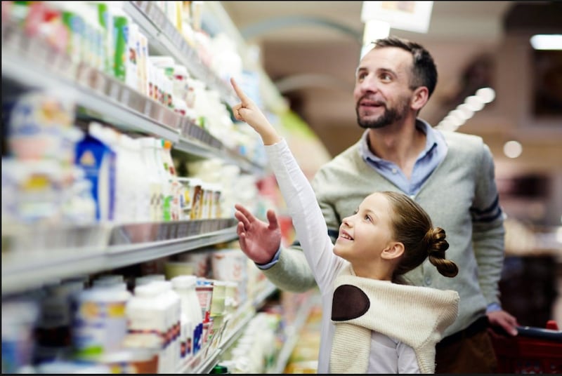 Niña y padre de compras en el súper mercado