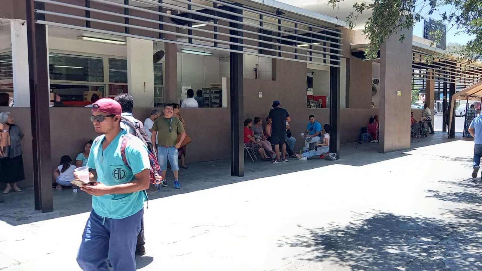 La gente aguarda en el calor sentados en sillas plegables y llevan agua y comida para enfrentar la larga espera.