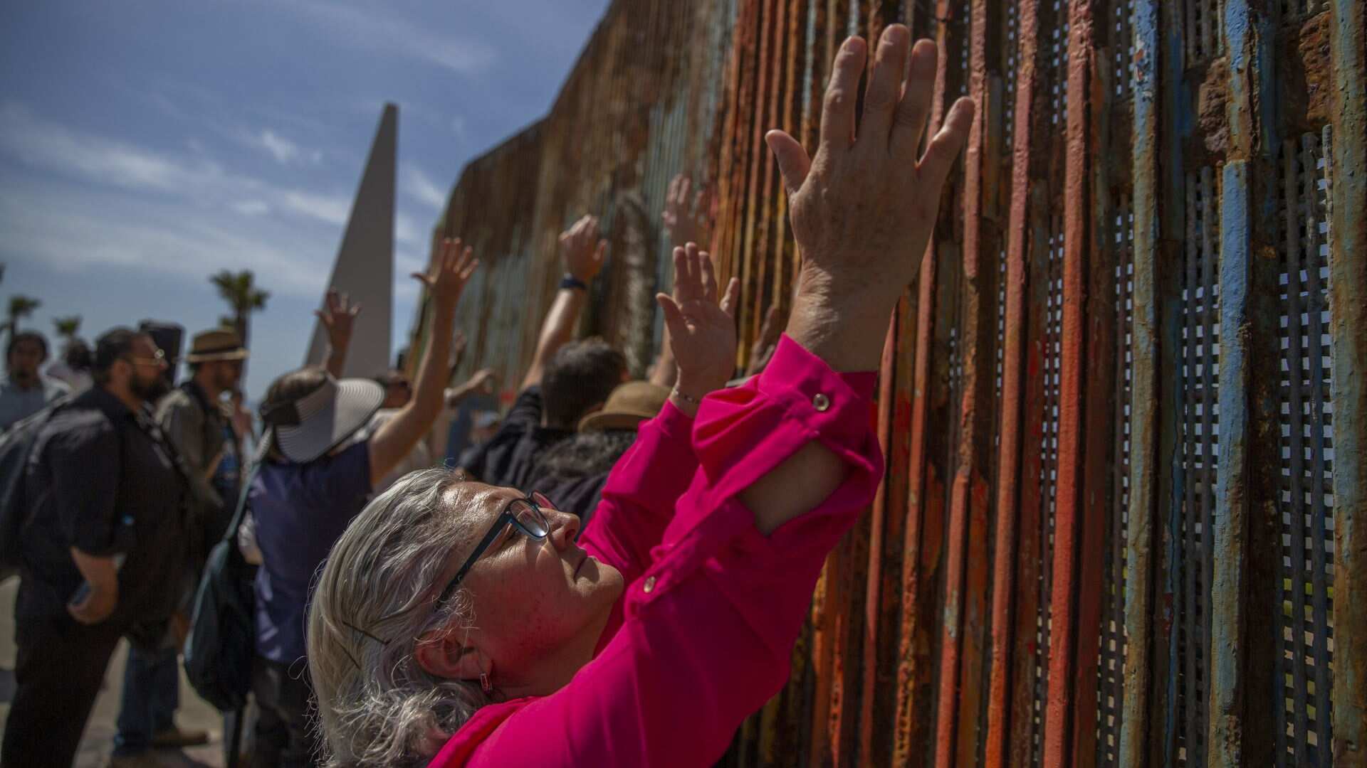 TIJUANA BAJA CALIFORNIA, 06ABRILMARZO2023.- Después de tres años del cierre del parque Binacional, durante esta tarde activistas del Parque de la Amistad se reunieron en el muro fronterizo para convivir. El reverendo Jhon Fanestil realizó una ceremonia religiosa en la que en ambos lados del muro compartieron la común. El activista y fundador, Daniel Watman también estuvo presente en el lugar plantando una flor en el jardín del parque y haciendo limpieza. Ambos expresaron la desaprobación ante el nuevo proyecto del gobierno Estadounidense de levantar un muro de 30 pies, que evitará la visibilidad entre ambos países. Agentes de la patrulla fronteriza estuvieron en el lugar y les pidieron “amablemente” a los activistas retirarse del lugar, a lo que ellos se negaron. FOTO: OMAR MARTÍNEZ/ CUARTOSCURO.COM
