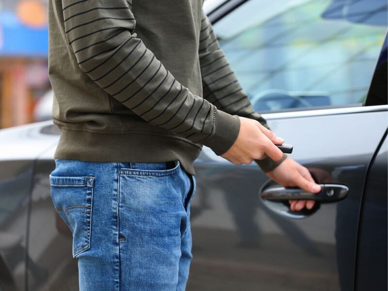 Persona abriendo la puerta de su auto con llave en mano, representando el acceso a comprar tu primer auto