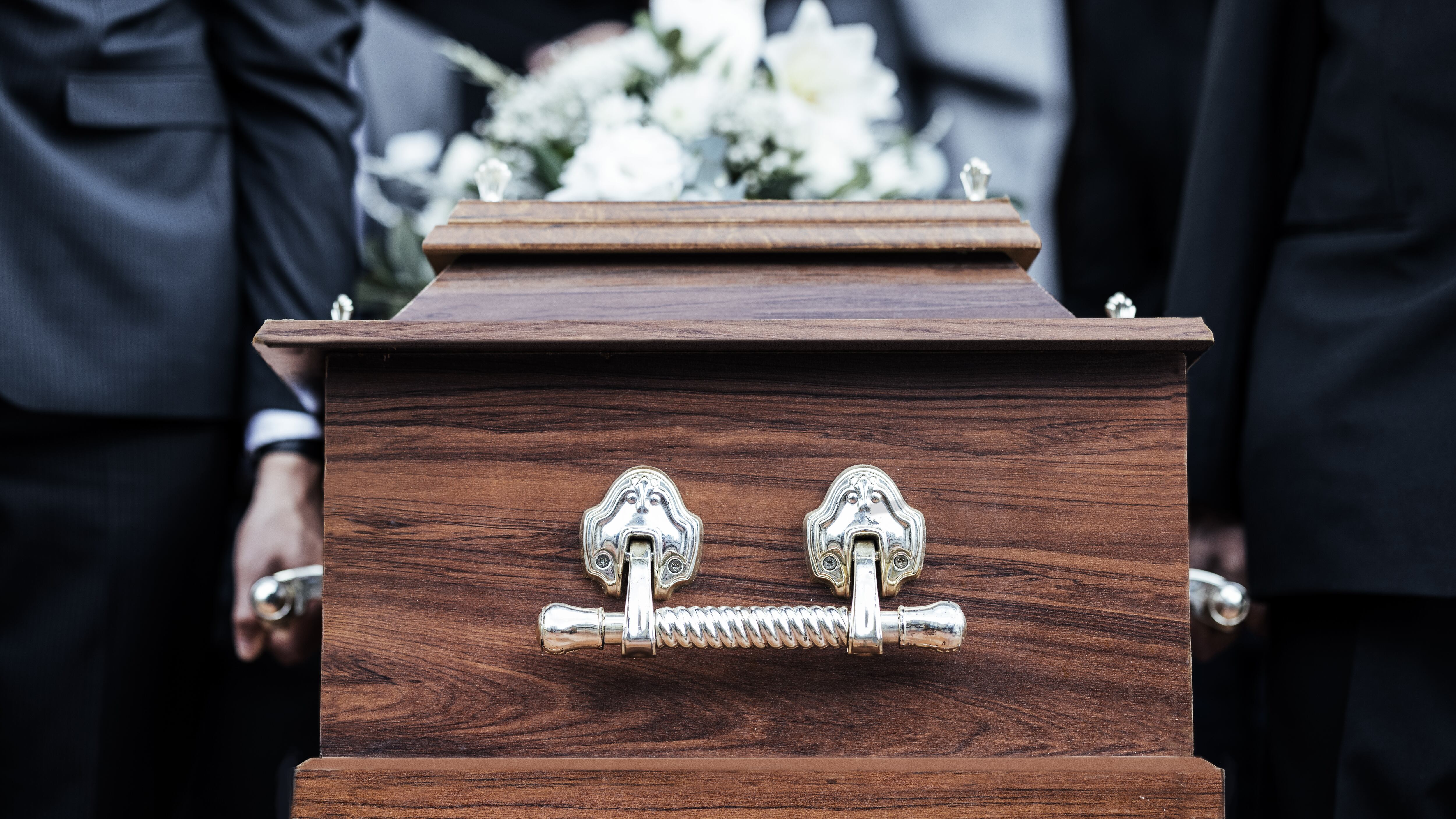 Ataúd, personas y funeral con muerte, dolor y servicio con la familia llevan el ataúd a la tumba al aire libre