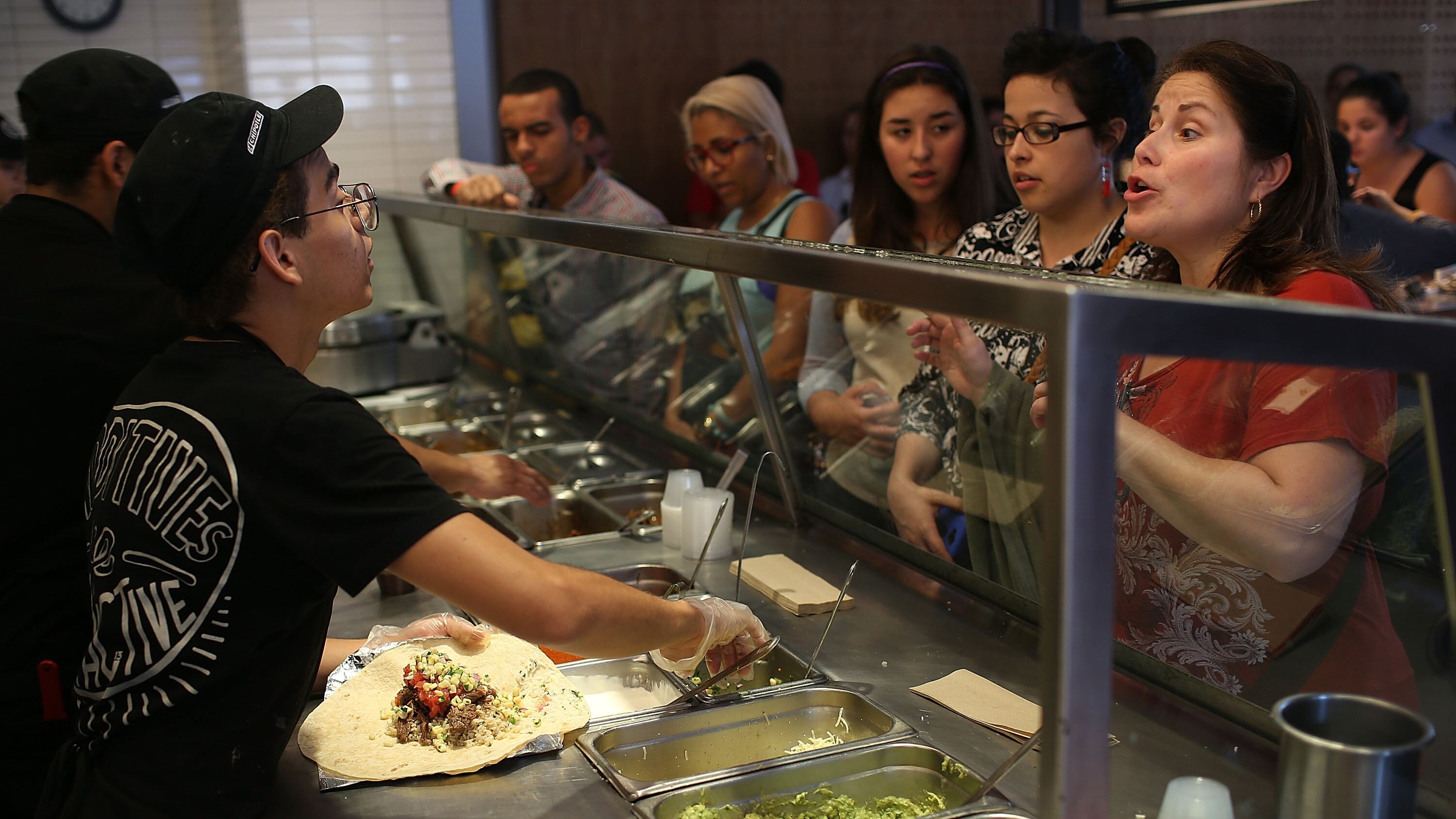 MIAMI, FL - APRIL 27:  Chipotle restaurant workers fill orders for customers on the day that the company announced it will only use non-GMO ingredients in its food on April 27, 2015 in Miami, Florida.  The company announced, that the Denver-based chain would not use the GMO's, which is an organism whose genome has been altered via genetic engineering in the food served at Chipotle Mexican Grills.  (Photo by Joe Raedle/Getty Images)