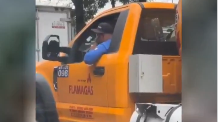 El chofer de una pipa de gas conducía con un cigarro en la mano