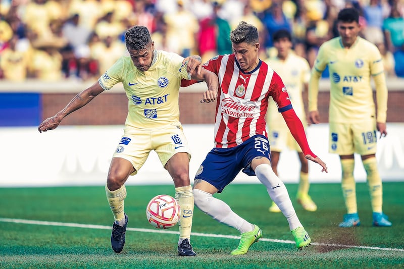 Jonathan Dos Santos disputa un balón con Cristian Calderón de Chivas