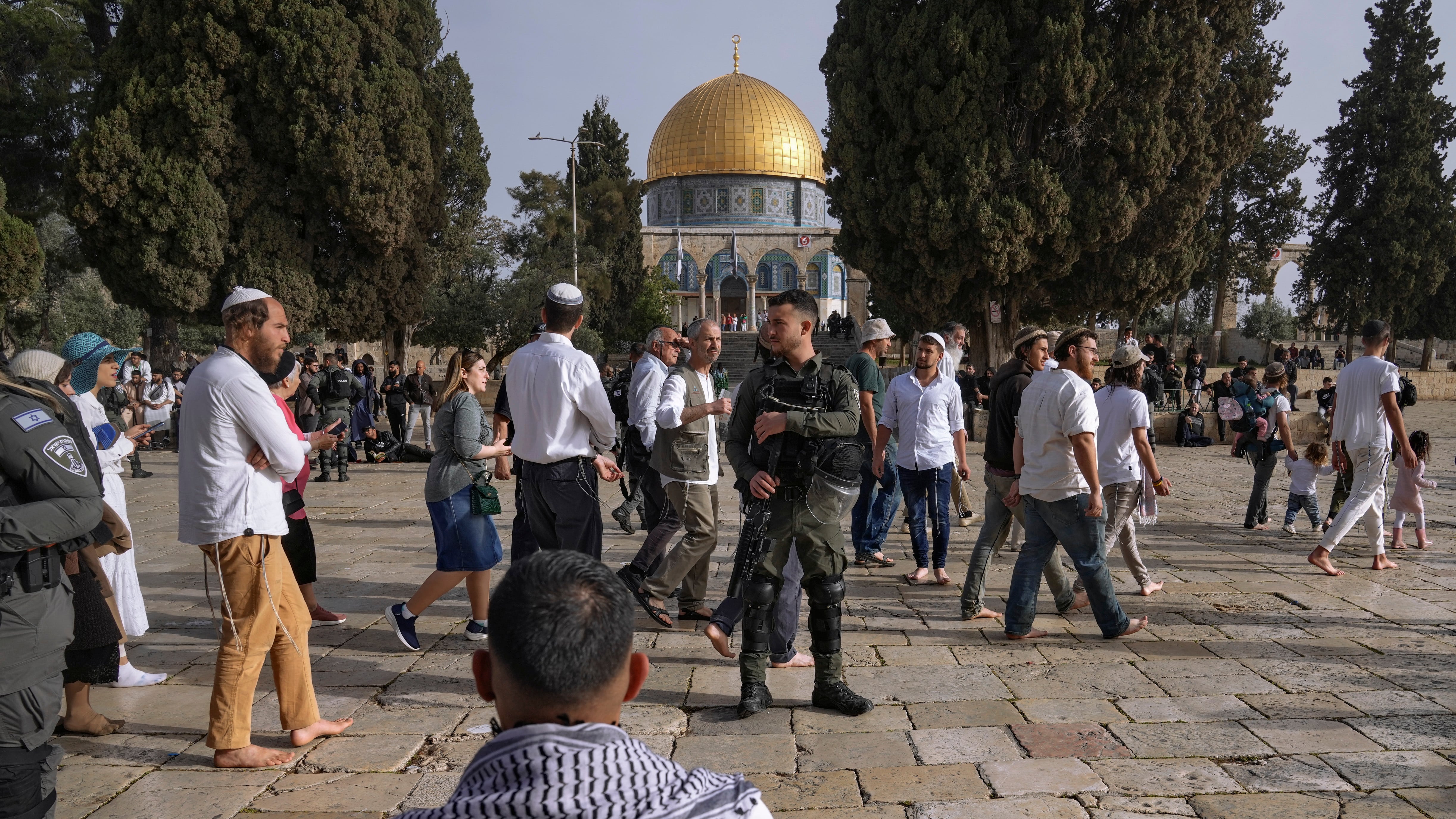 Policías israelíes escoltan a visitantes judíos en que celebran la Pascua judía en el complejo de la Mezquita de Al Aqsa, conocido por los musulmanes como Noble Santuario y por los judíos como Monte del Templo, en el casco antiguo de Jerusalén, durante el mes sagrado del Ramadán, el domingo 9 de abril de 2023. (AP Foto/Mahmoud Illean)