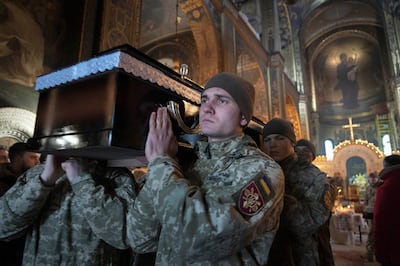 Militares ucranianos portan el féretro de su camarada durante la ceremonia fúnebre por Volodymyr Yezhov, muerto en un campo de batalla con las fuerzas rusas, en la Catedral de San Volodymyr en Kyiv, Ucrania, el martes 27 de diciembre de 2022. Yezhov fue diseñador de juegos en el desarrollo del juego Cossacks 2. También fue uno de los autores del juego S.T.A.L.K.E.R.: Clear Sky. Yezhov también fue uno de los deportistas electrónicos ucranianos más famosos: jugaba a StarCraft con el sobrenombre de Fresh. Desde la invasión rusa, Volodymyr Yezhov fue al frente y luchó como parte del escuadrón de voluntarios. (AP Photo/Efrem Lukatsky)