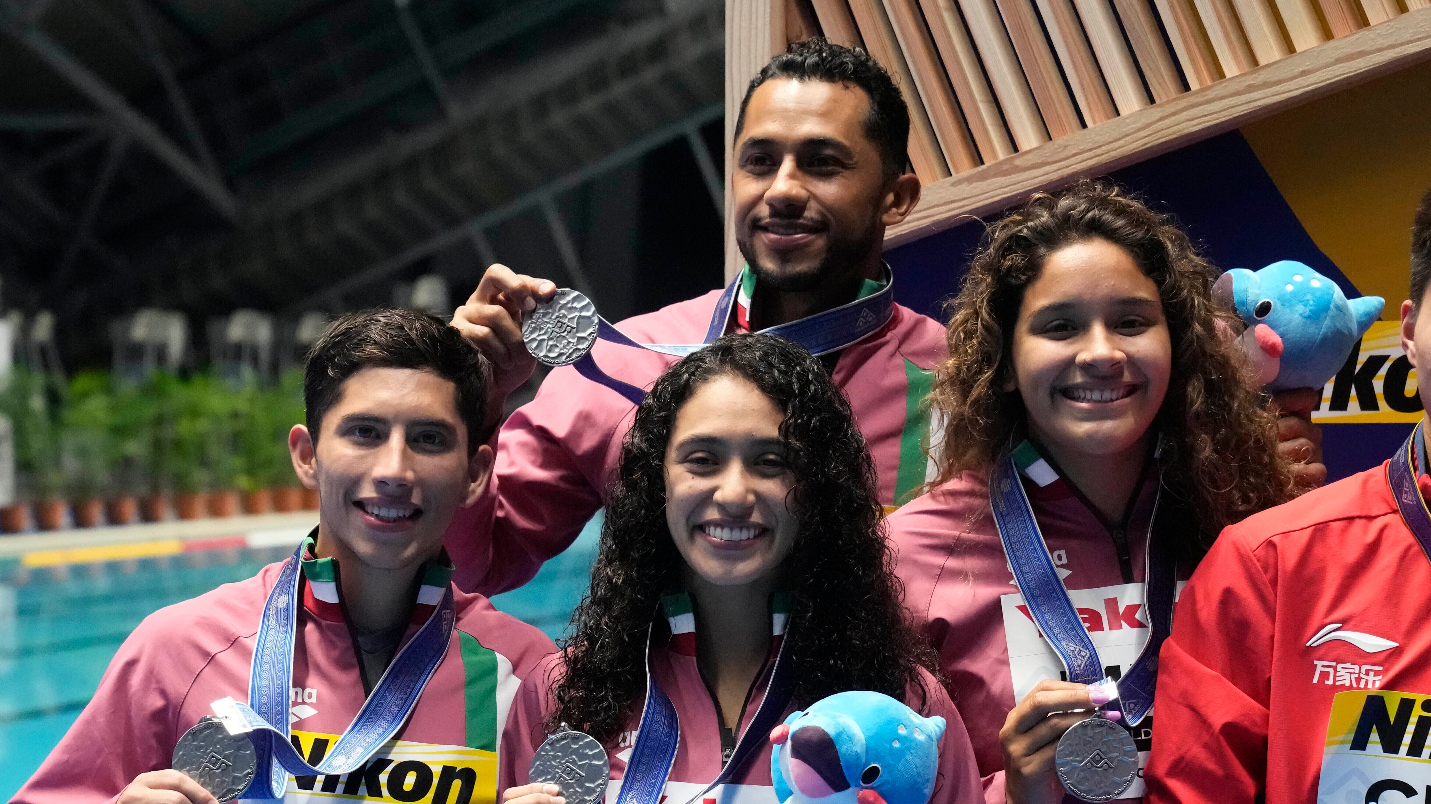 El equipo de México celebra tras ganar una medalla de plata en la competencia mixta en el Mundial de natación, el martes 18 de julio de 202