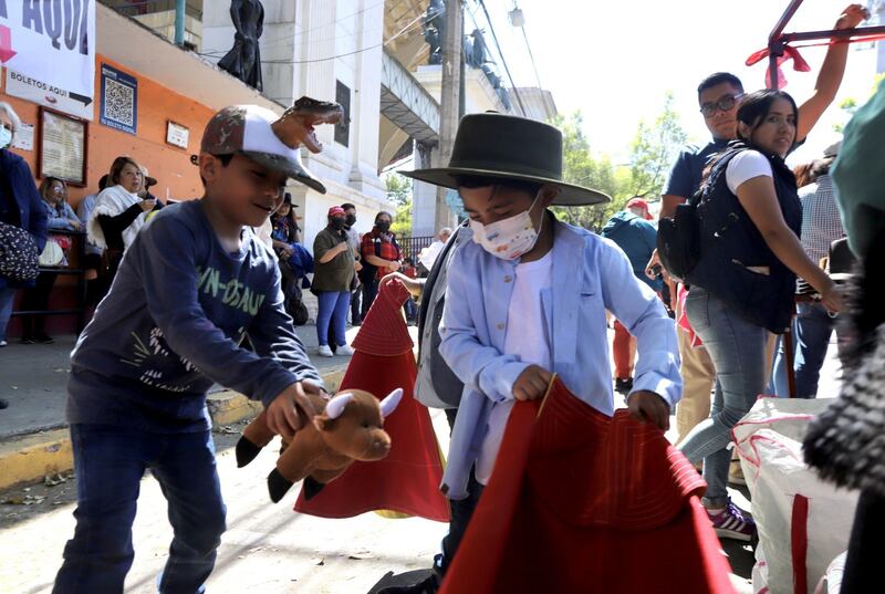 Niños juegan a los toros, mientras aficionados y trabajadores de la Plaza de Toros México se reúnen a las afueras de este inmueble para recabar firmas en defensa de la llamada fiesta brava y de sus fuente de trabajo.