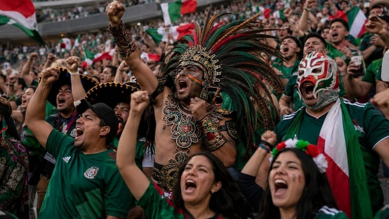 Aficionados de la selección mexicana celebran en las gradas del Estadio Azteca durante un partido de futbol internacional.