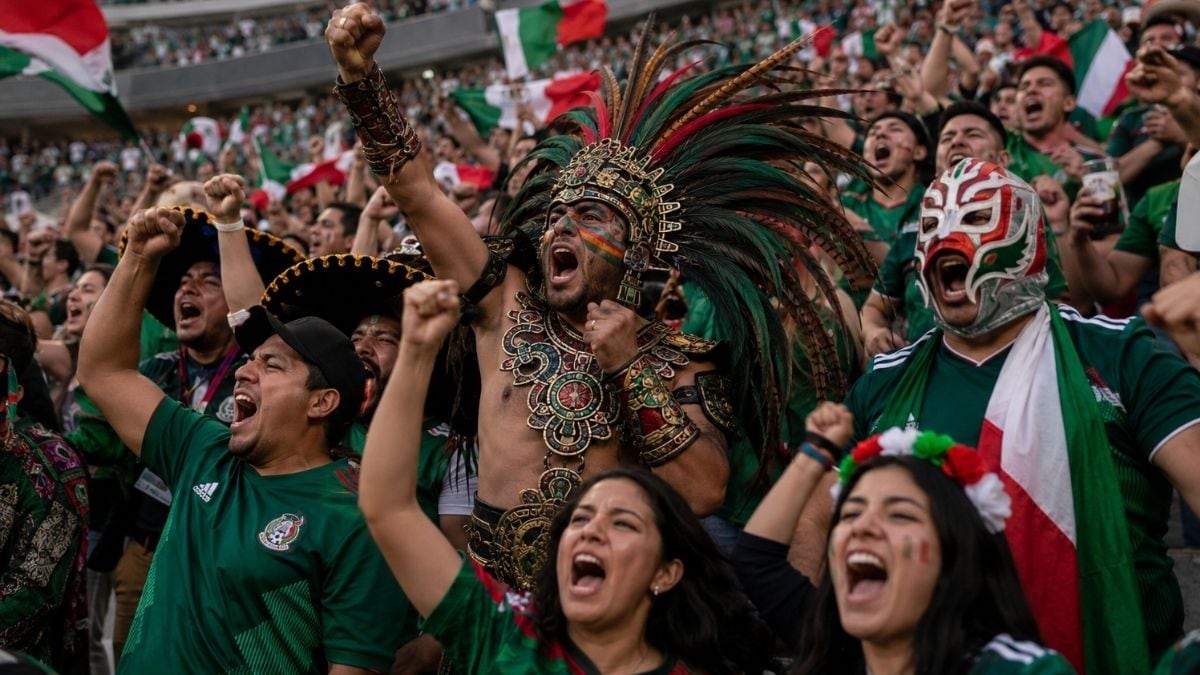 Aficionados de la selección mexicana celebran en las gradas del Estadio Azteca durante un partido de futbol internacional.