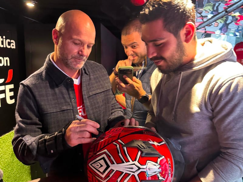 Luis García firma un balón durante el evento de presentación de “Tercer Tiempo NESCAFÉ”.