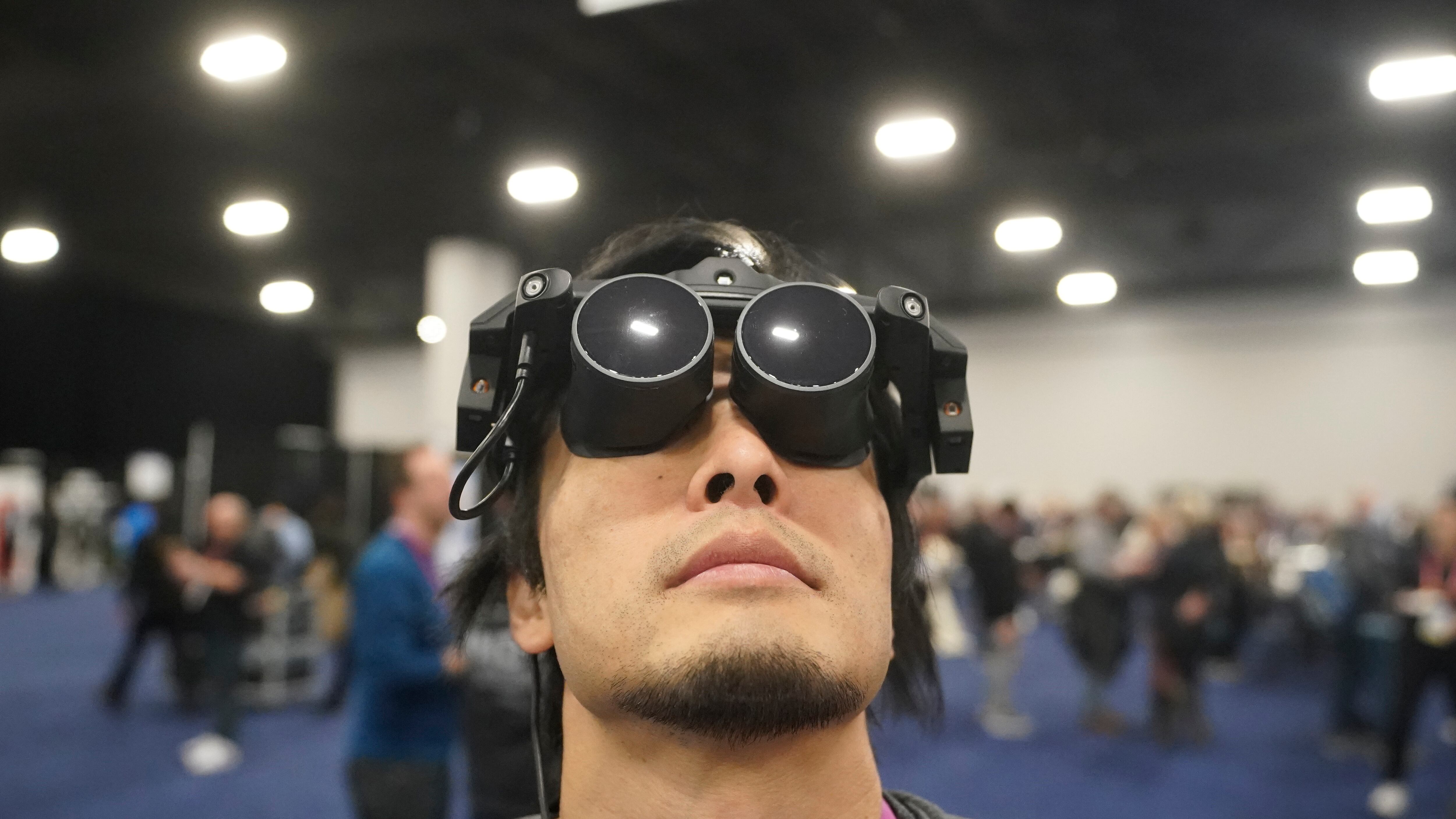 Takuma Iwasa usa el Megane X en el stand de Shiftall previo a la apertura de la feria tecnológica CES, el martes 3 de enero de 2023 en Las Vegas. Megane X es un dispositivo de realidad virtual ultraligero y ultracompacto.