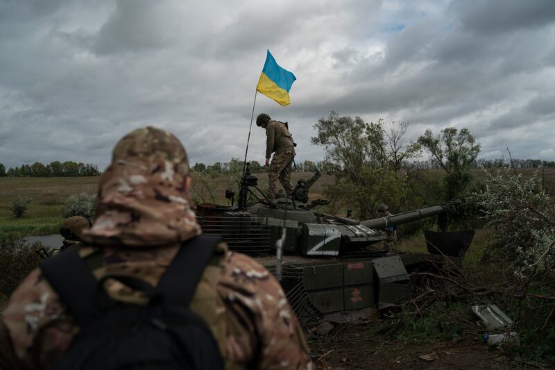 ARCHIVO - Un soldado de la guardia nacional ucraniana sobre un tanque ruso destruido en una zona cercana a la frontera con Rusia, en la región de Kharkiv, Ucrania, el 19 de septiembre de 2022. Una rápida contraofensiva ucraniana a principios de este mes que obligó a las tropas rusas a retirarse de amplias franjas de la región nororiental de Kharkiv ha obligado al Kremlin a apresurarse a absorber las zonas controladas por Rusia en el este y el sur de Ucrania. (AP Photo/Leo Correa, Archivo)