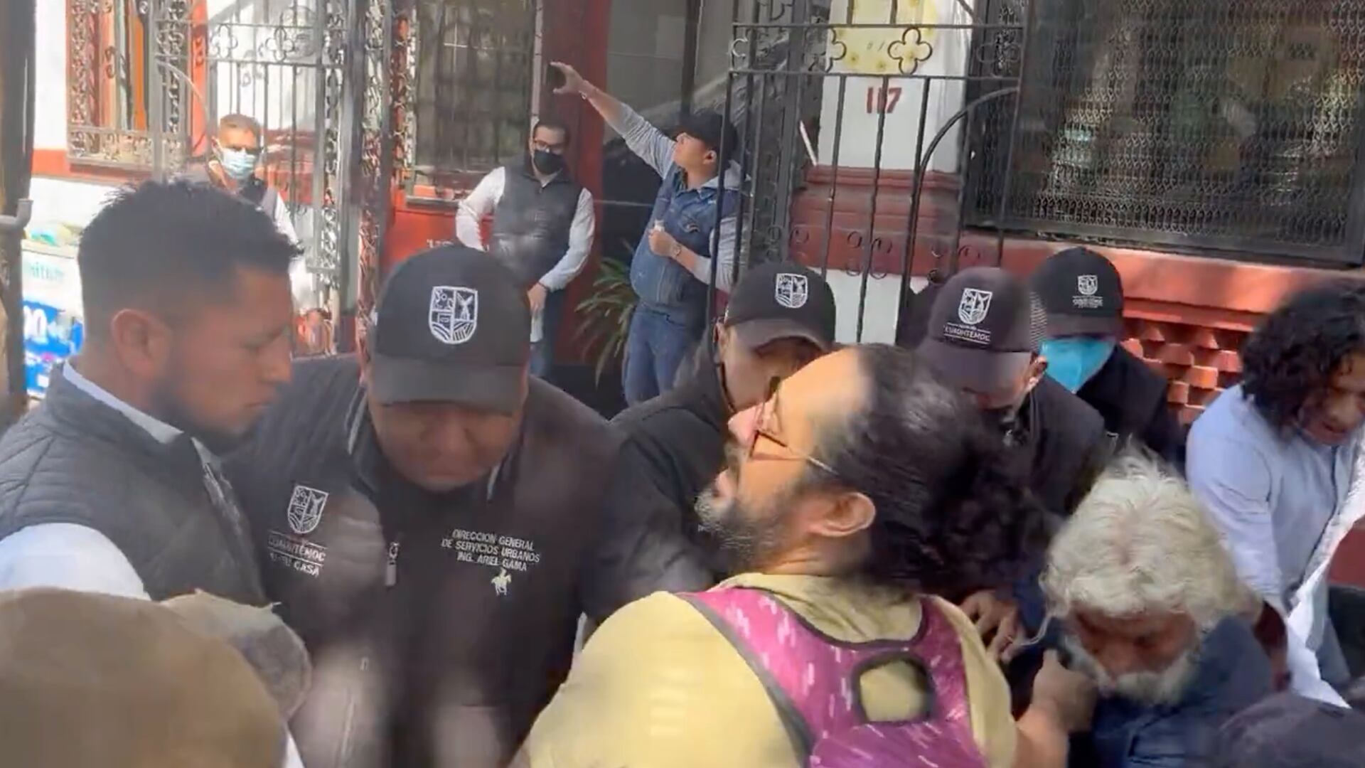 Empiujones y golpes entre funcionarios y manifestantes afuera de la casa de Sandra Cuevas.