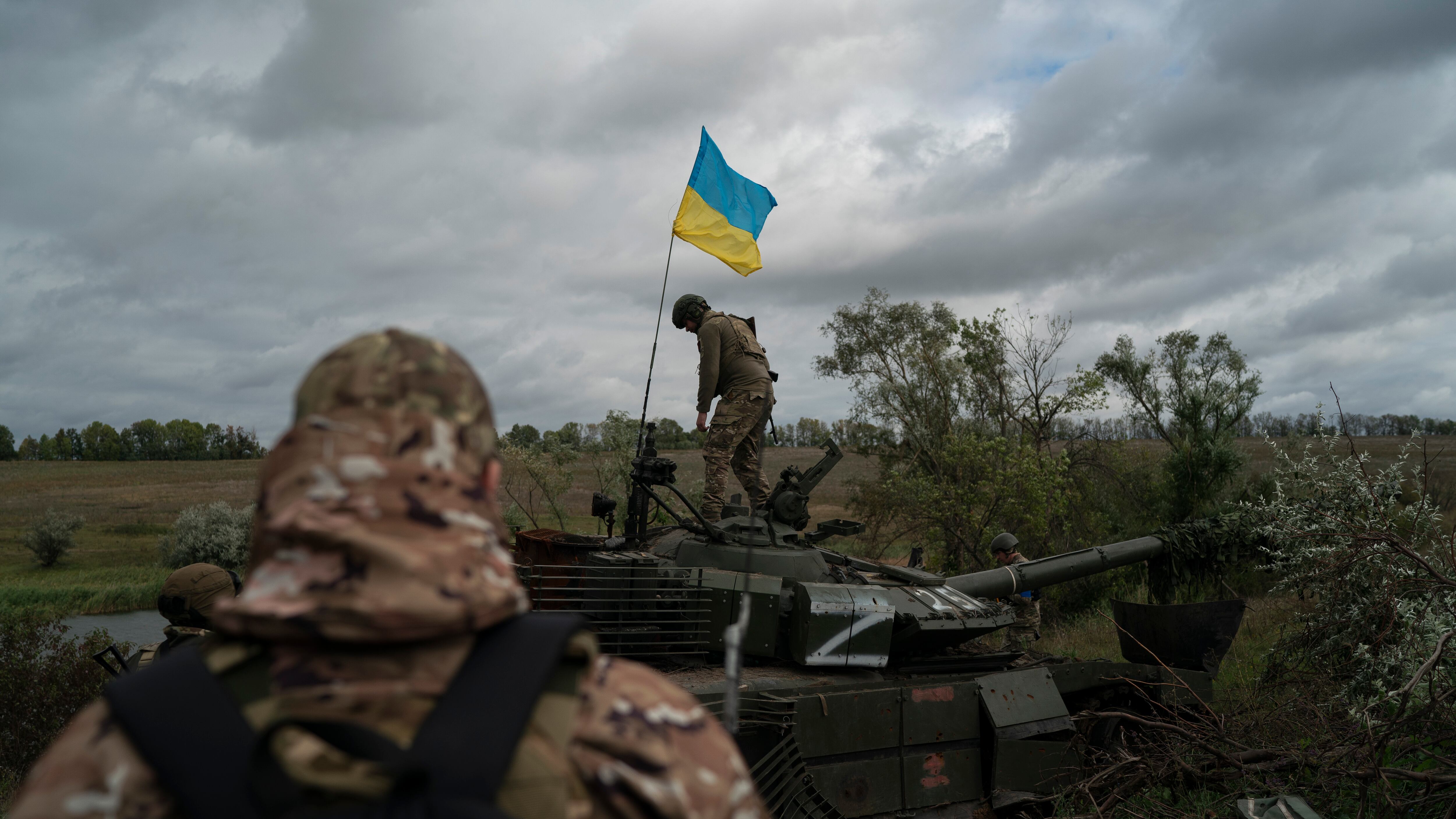 Un militar ucraniano camina sobre un tanque ruso destruido cerca de la frontera con Rusia