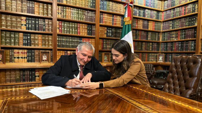 Secretario de Gobernación, Adán Augusto López, firmando documento del cambio de horario de Ciudad Juárez, acompañado de la diputada federal morenista, Andrea Chávez Treviño.