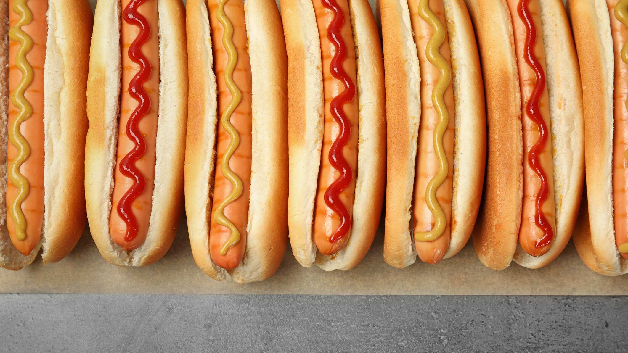 Hot dog with huge sausage and various toppings