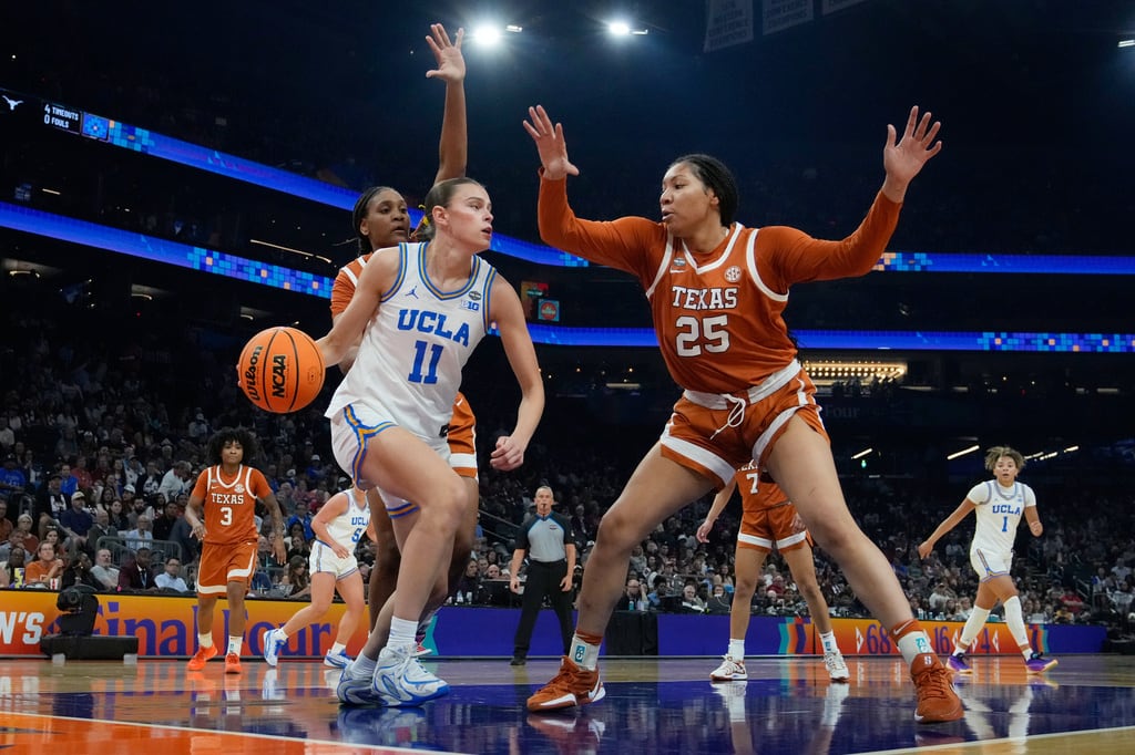UCLA guard Gabriela Jaquez (11) dribbles against Texas forward Breya Cunningham (25) during the first half of a women's NCAA college basketball tournament semifinal game at the Final Four, Friday, April 3, 2026, in Phoenix. (AP Photo/Ross D. Franklin)