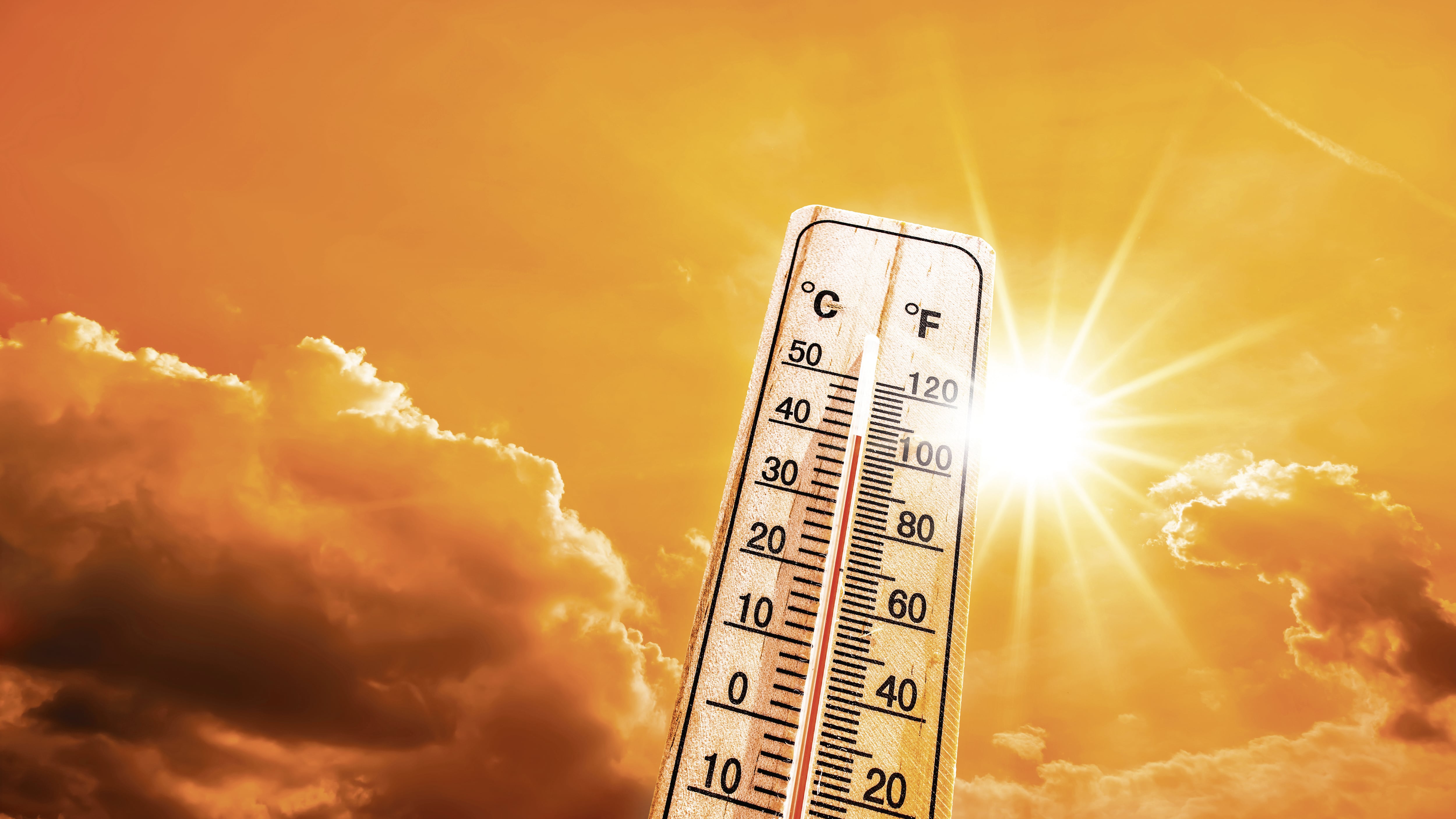 Verano caluroso o fondo de ola de calor, sol brillante en el cielo naranja con termómetro