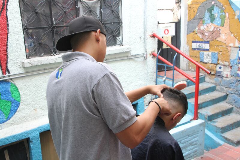 Migrantes se cortan el cabello en Casa Tochan.